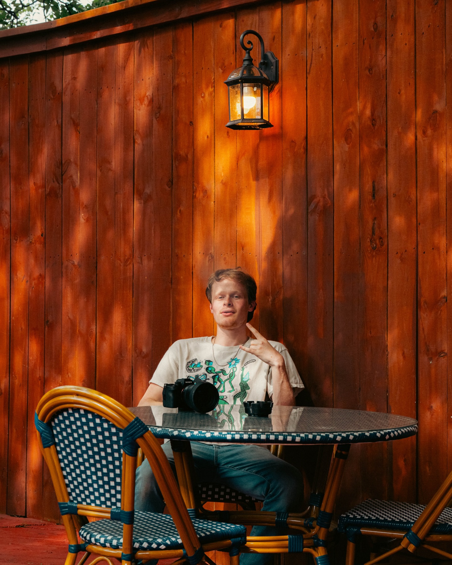 Guest relaxing at a mosaic table against the cedar wall on the Sip Haus patio