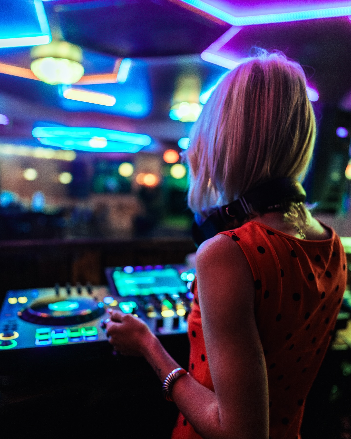 DJ performing under the neon hexagonal ceiling at Sip Haus Austin