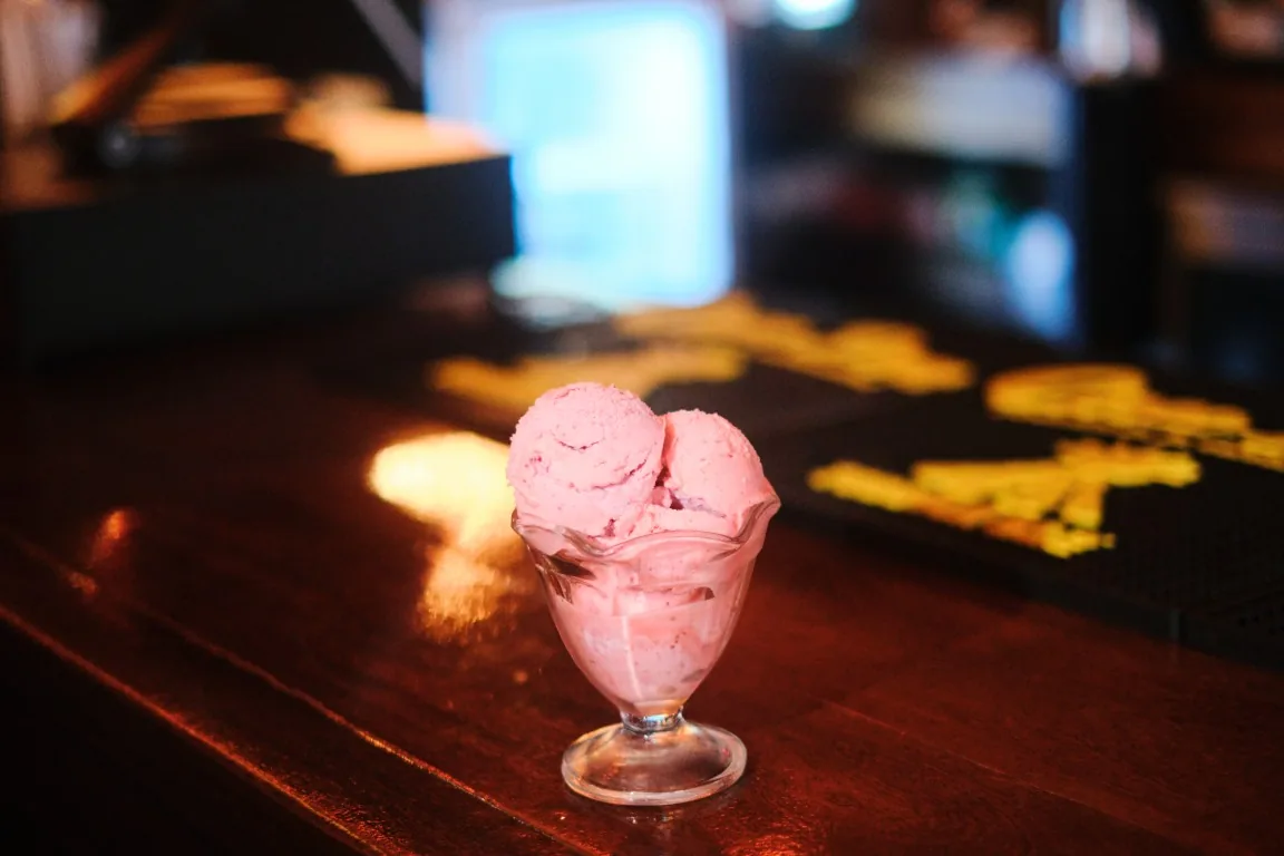 Two scoops of strawberry gelato in a glass coupe on the Sip Haus bar
