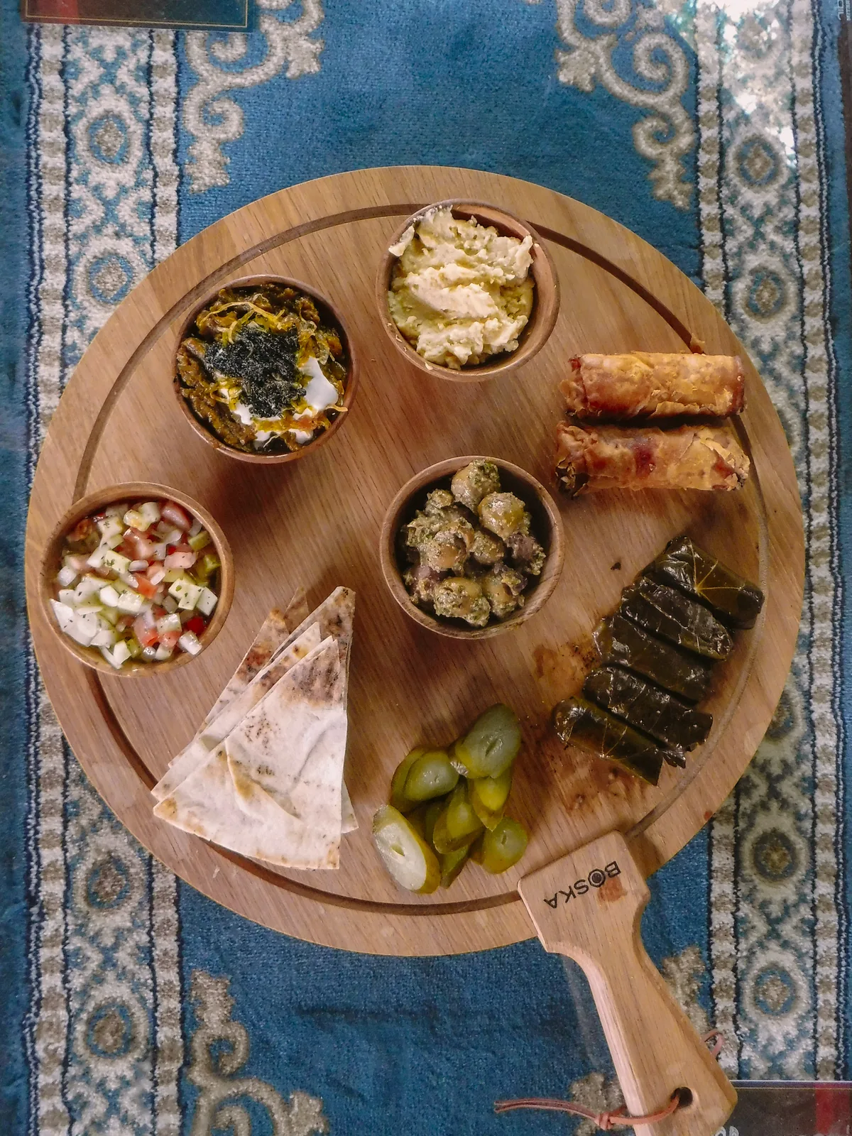 Overhead view of the Sip Haus Persian Platter on a wooden board over a Persian rug