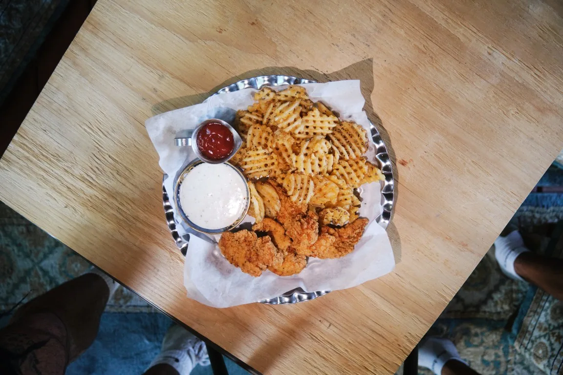 Overhead view of Sip Haus chicken tenders with waffle fries