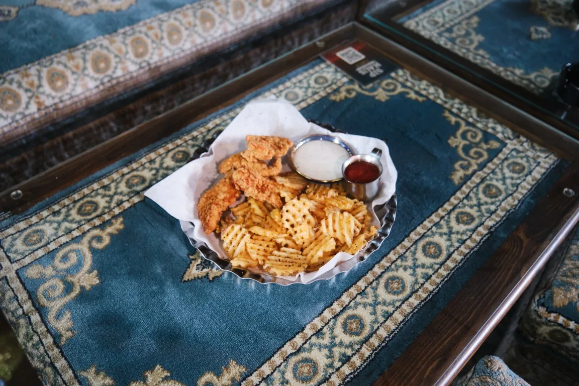 Sip Haus chicken tenders with waffle fries, ranch and ketchup on a Persian rug table